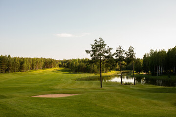 The photo shows a golf course, green grass and trees.