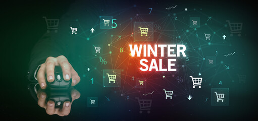 hand holding wireless peripheral with WINTER SALE inscription, online shopping concept