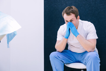 Tired exhausted doctor after long shift fighting against Coronav