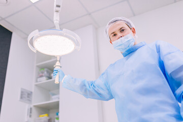 Fototapeta premium Surgeon moving the surgical reflector at the operating room
