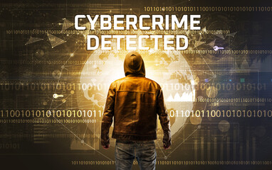 Faceless hacker at work with CYBERCRIME DETECTED inscription, Computer security concept © ra2 studio
