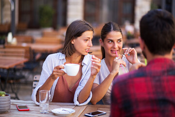 Girlfriends gossip while drinking coffee