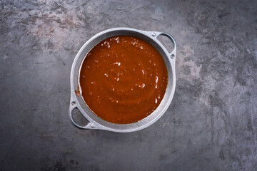 Hot and spicy barbecue sauce offered as overhead view in a modern design bowl with copy space