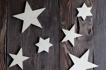 Fototapeta na wymiar Wooden stars made of plywood on a dark wooden background