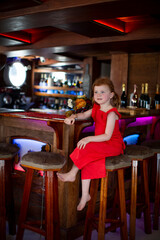 Little girl sitting at a bar