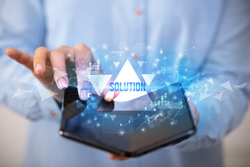 Businessman holding a foldable smartphone with SOLUTION inscription, business concept