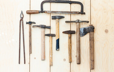 Set of vintage well used hand construction tools for handyman, hammers, on a wooden background .