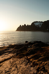 Summer time on Senja island, Norway. Beautiful sunset during the white night, amazing sharp mountains and norwegian sea in the background.