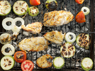 Grilled fish with vegetables and bread on the grill. Outdoor lifestyle picnic..
