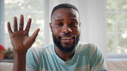African smiling man waving hand in camera talking on video call
