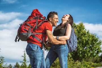 Couple of hikers in the mountains laughing