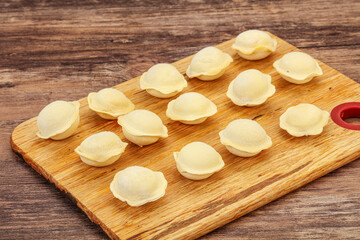 Obraz na płótnie Canvas Raw dumplings over board for cooking