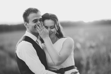 Happy bride and groom hug each other in the park at sunset. Wedding. Happy love concept.
