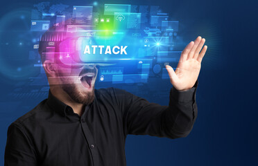 Businessman looking through Virtual Reality glasses with ATTACK inscription, innovative security concept