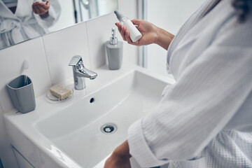 Female holding a hydrating lotion in her hand