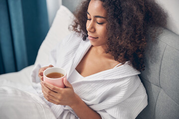 Woman holding a mug of tea with both hands