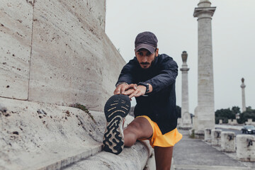 giovane atleta sportivo esegue un allungamento per la gamba durante una sessione di allenamento in...
