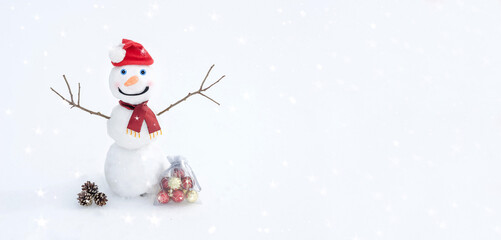 Christmas and New Year banner background with copy space. Snowman in Santa's red hat and scarf on the snow with Christmas balls. Winter card.
