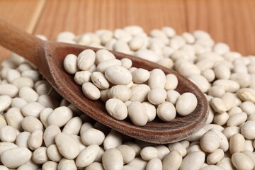 Navy beans in wooden spoon
