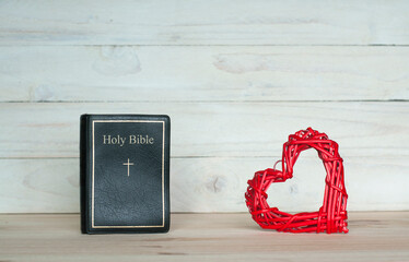 Holy Bible. Bible on the table. On a wooden background. Red heart
