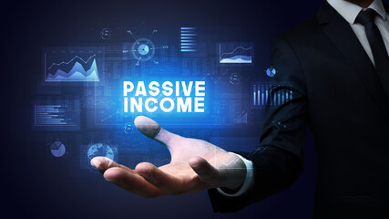 Hand of Businessman holding PASSIVE INCOME inscription, business success concept