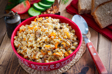 Barley porridge with stewed beef in a ceramic bowl, selective focus
