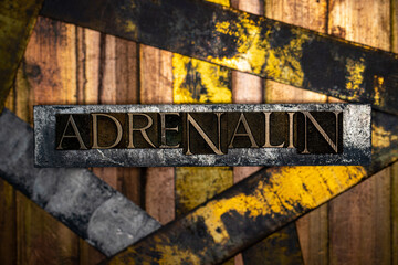 Adrenalin text formed with real authentic typeset letters on vintage textured silver grunge copper and gold background © IHX