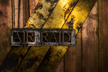 Air Raid text formed with real authentic typeset letters on vintage textured silver grunge copper and gold background