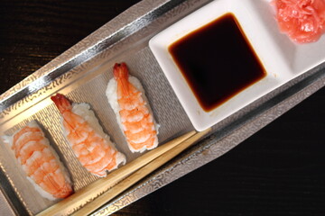 Sushi nigirizushi with soy sauce and gari on metal tray with chopsticks