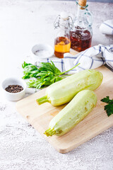 Fresh zucchini on a wooden board with a knife