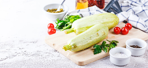 Fresh zucchini on a wooden board with a knife