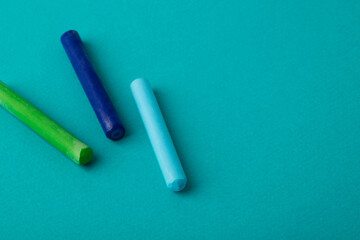 pastel crayons on turquoise background close up