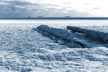 Winter landscape. Sea covered blocks of ice on the horizon are ships at anchorage