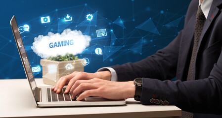 Businessman working on laptop with GAMING inscription, modern technology concept