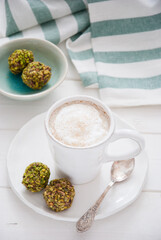 A cup of coffee and pistachio candies