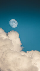 Naklejka na ściany i meble Evening sky with clouds and bright partial moon. Nightsky with large moon, nature background. Vertical photo.