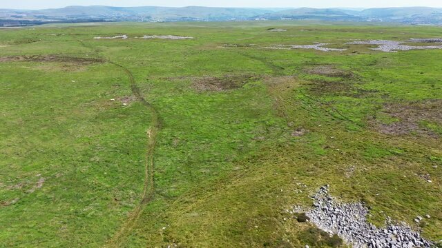 Aerial drone view flying over collapsed sinkholes and cave entrances on remote moorland (Crescent Cave area, Brecon Beacons, South Wales, UK)