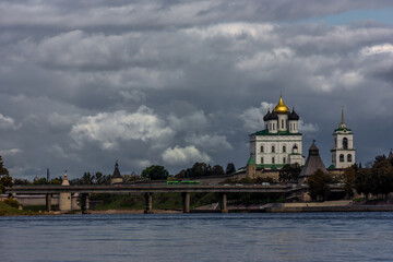Fototapeta na wymiar Panorama of the embankment of the river, defensive walls and towers next to the Christian Cathedral in the historical center of the old city of Pskov, Russia,