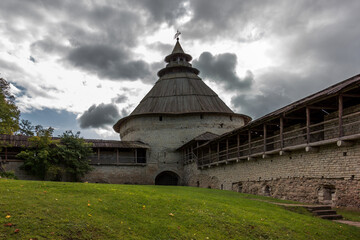 The defensive tower on the walls of the Pskov Kremlin and the watchtower in the center of the old...
