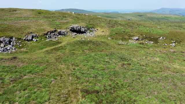 Low altitude drone view of the entrance to the historic and remote Chartist Cave on Llangynidr Moors in South Wales, UK