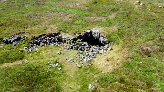Low altitude drone view of the entrance to the historic and remote Chartist Cave on Llangynidr Moors in South Wales, UK