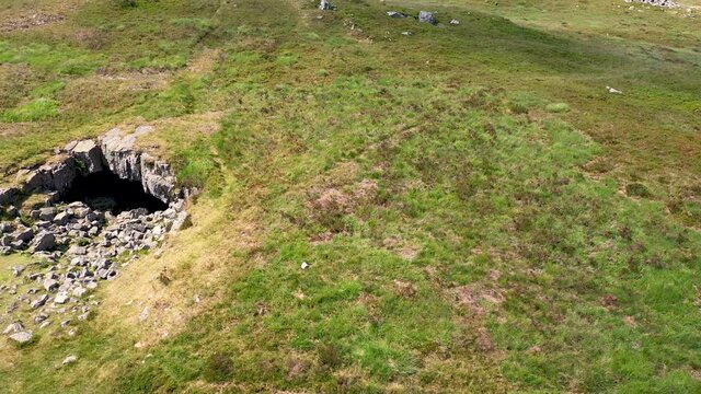 Low altitude drone view of the entrance to the historic and remote Chartist Cave on Llangynidr Moors in South Wales, UK