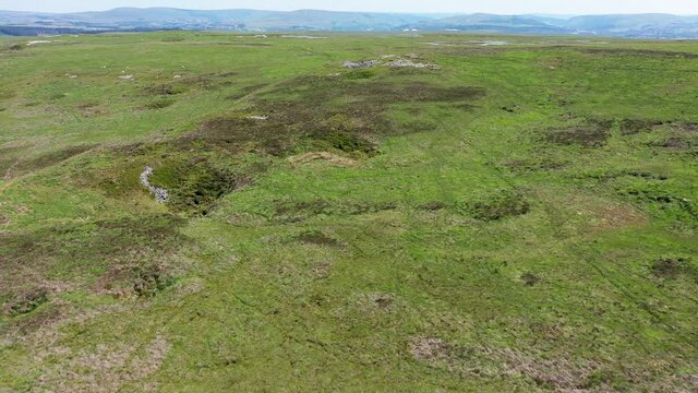 Aerial drone view flying over collapsed sinkholes and cave entrances on remote moorland (Crescent Cave area, Brecon Beacons, South Wales, UK)