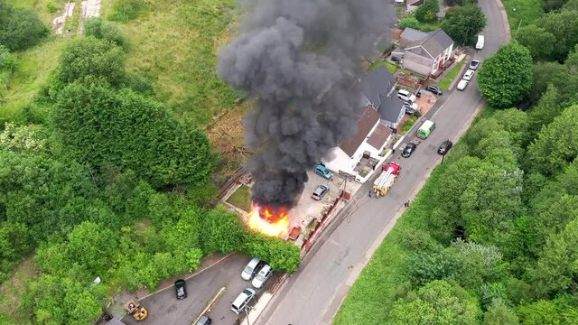 EBBW VALE, WALES, UK - JUNE 26 2020: Aerial view of firefighters tackling a small blaze in a domestic outbuilding.  The fire was extinguished within minutes.