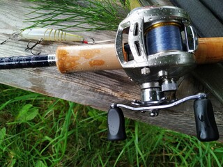 Close-up fishing reel on wood and grass. ready for fishing concept