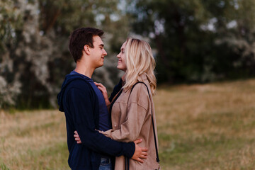 young guy and girl look at each other in summer