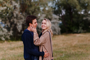 Smiling girl hugs boyfriend in summer