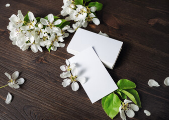 Obraz na płótnie Canvas Photo of blank white business cards and flowers on wooden background. Template for ID.