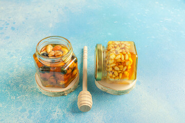 Jar of honey and nuts with a honey spoon