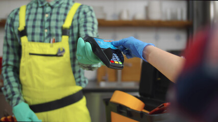 Handyman and customer making transaction with credit card and terminal